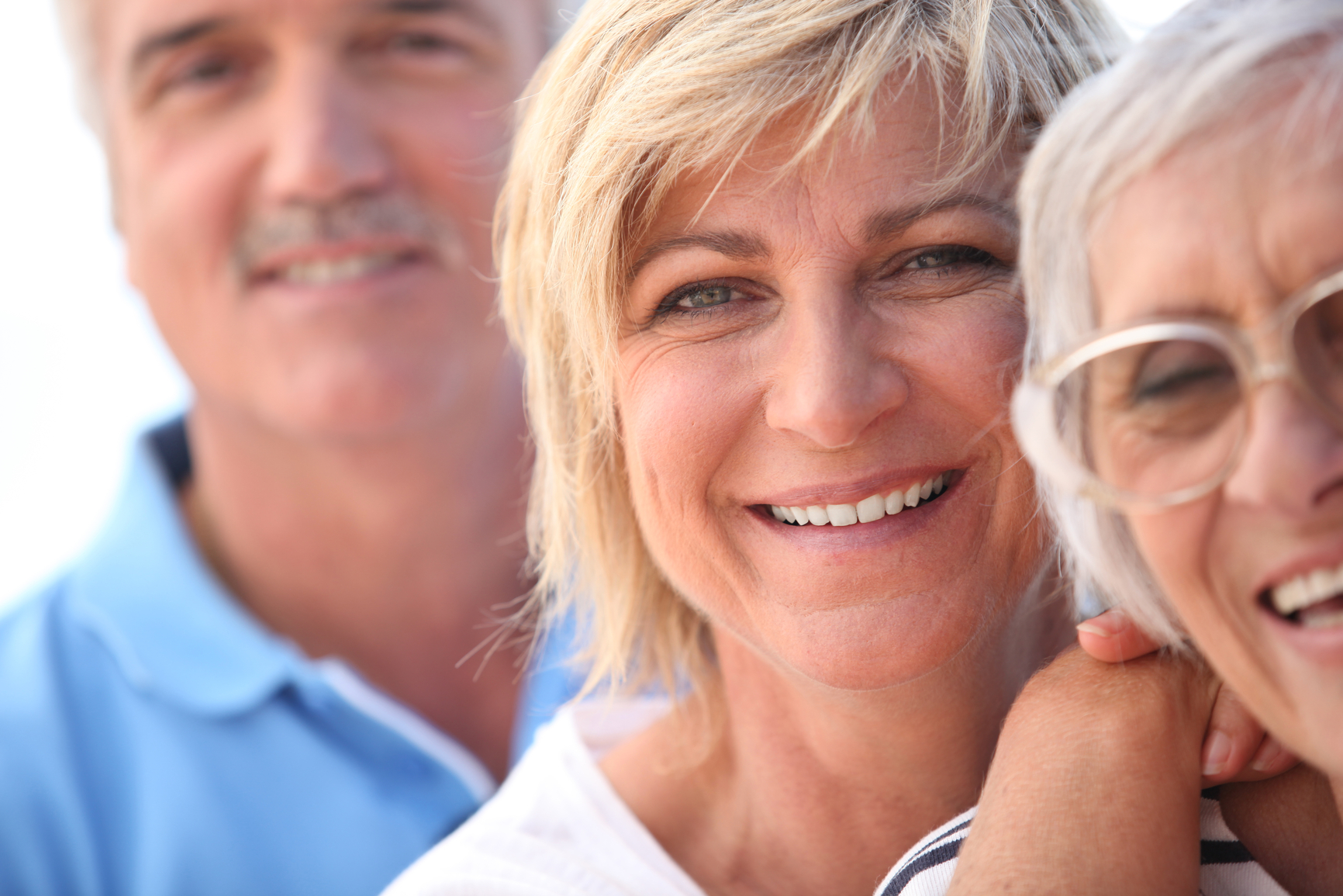 Photo: Close up of three smiling middle-aged people